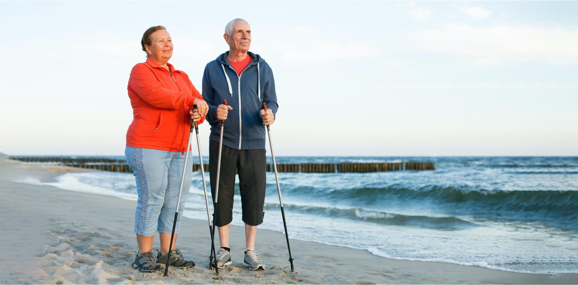 Seniorzy spacerujący po plaży