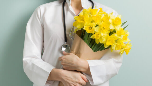 Zdrowych i radosnych Świąt Wielkanocnych - lekarka z bukietem kwiatów