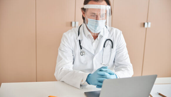 Certyfikaty P1 - powiadomienia e-mail - lekarz pracujący na laptopie w gabinecie